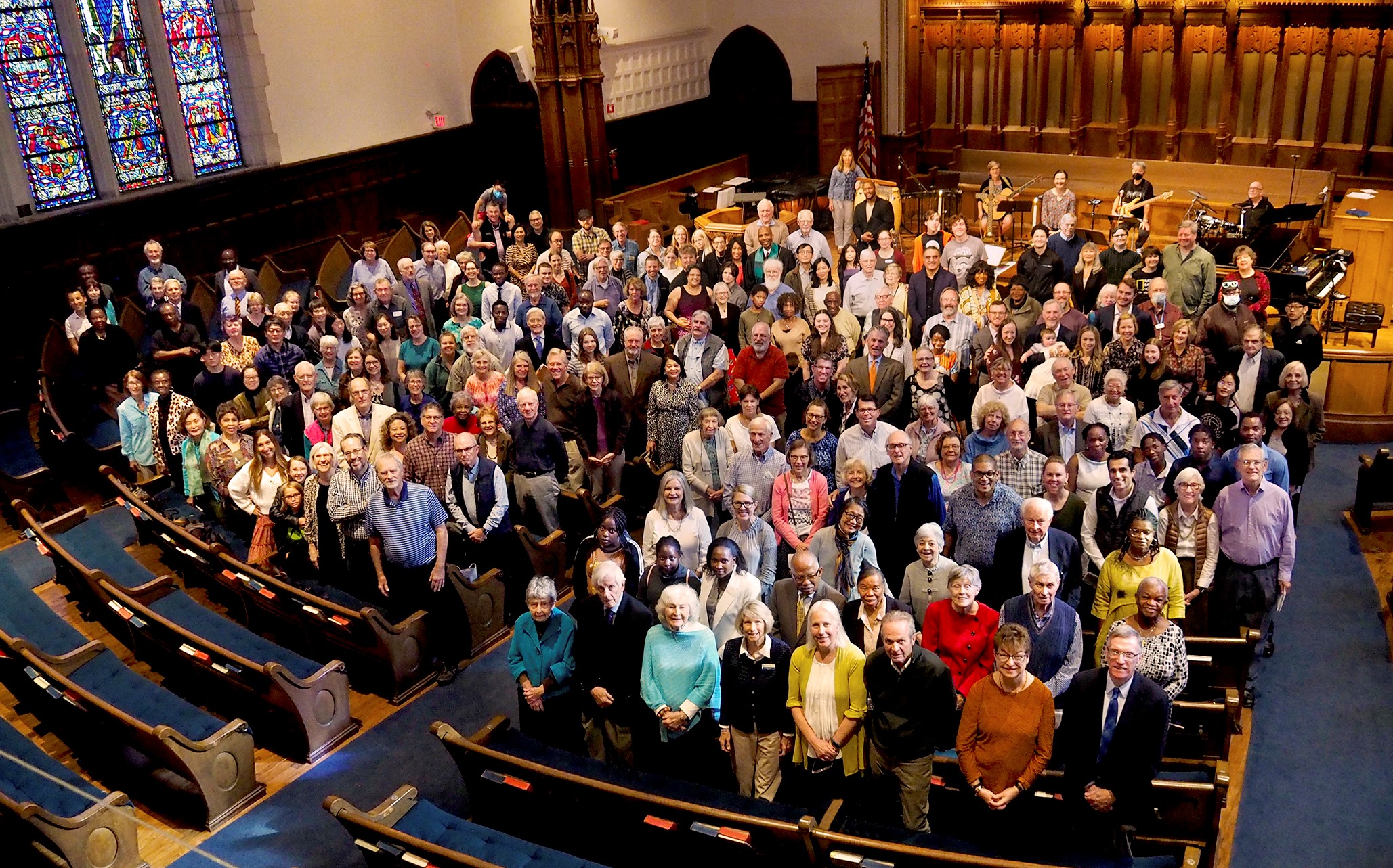 Group photo of congregation standing inside a church sanctuary.